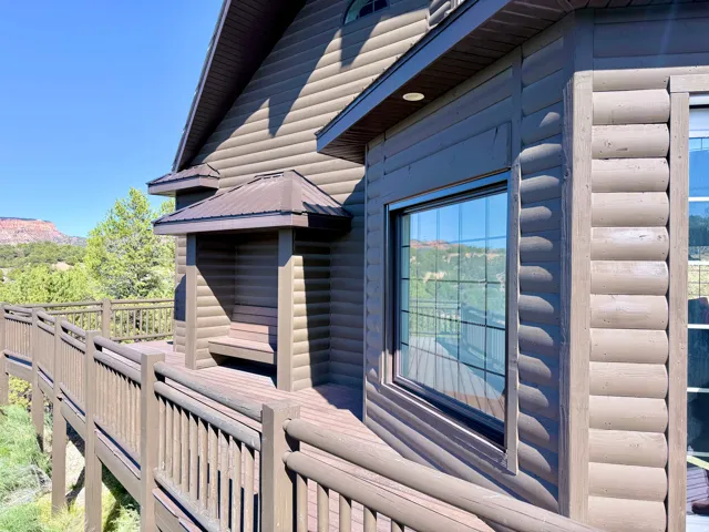 Exterior with log-style siding and a prominent window