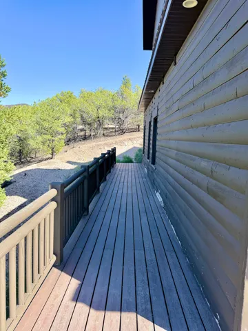 Expansive outdoor deck featuring composite decking, durable railings, and a log-style exterior