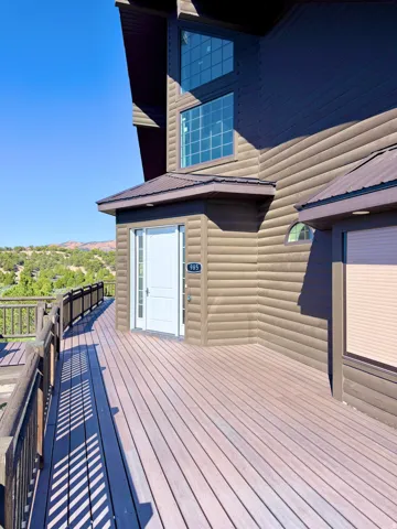 Expansive outdoor deck featuring wood-finish decking and dark wood railings