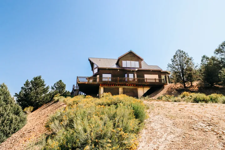 Back of house featuring a wooden deck and a metal roof