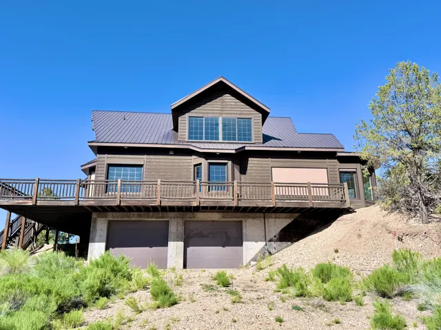Multi-level residence featuring wood siding and a metal roof