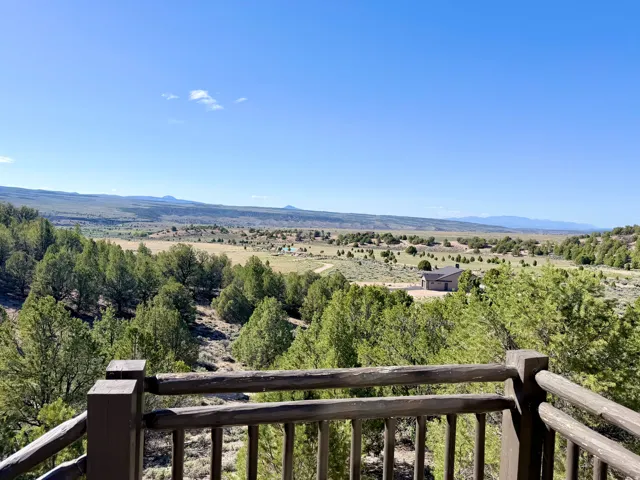 Wood-finish railing framing extensive natural landscape with distant mountains