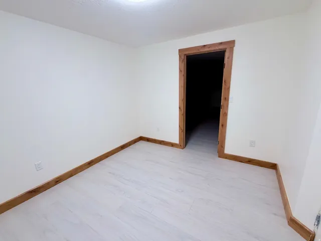 Neutral white walls with wood-finish trim and light-toned wood-finish flooring