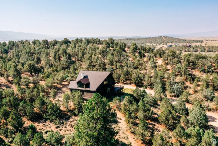 View from above of property featuring mountains and a heavily wooded area