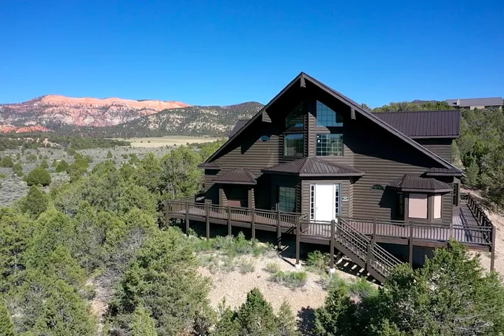 Wood-sided residence featuring a steep-pitched metal roof and expansive multi-level decking