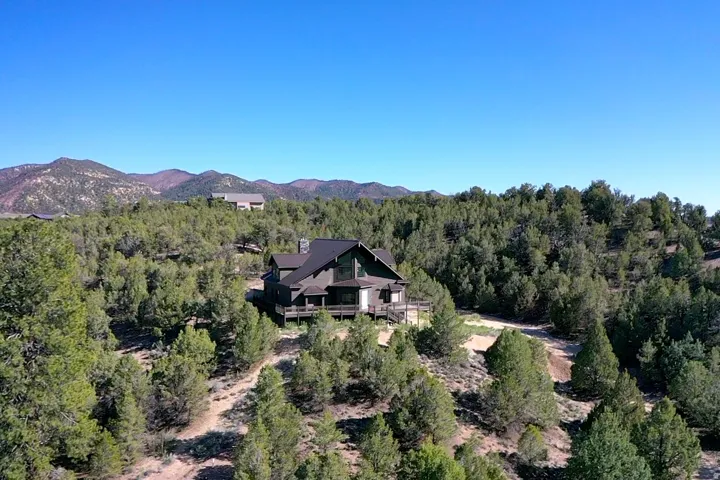 Contemporary mountain-style residence featuring a dark-toned exterior, multiple levels, and extensive decking
