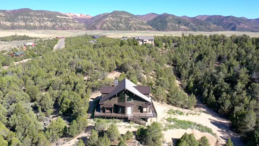 Contemporary two-story home with a multi-level deck, set among abundant mature trees