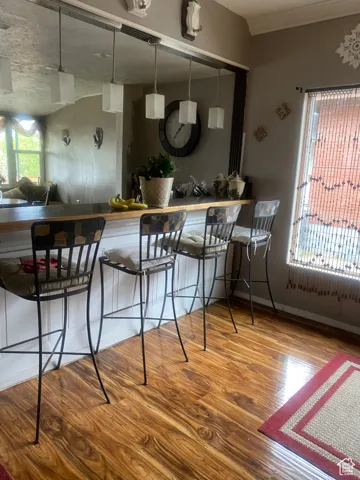 Kitchen featuring baseboards, a kitchen bar, and wood finished floors