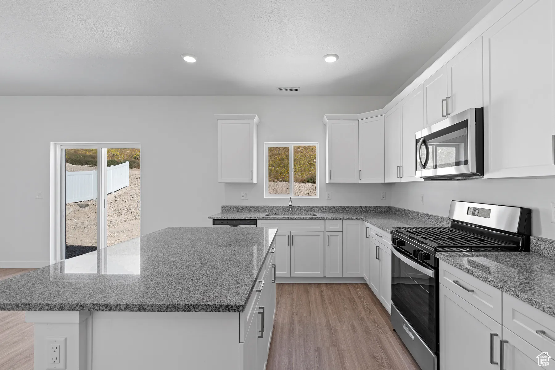 Kitchen with light wood-style floors, a sink, a center island, and appliances with stainless steel finishes