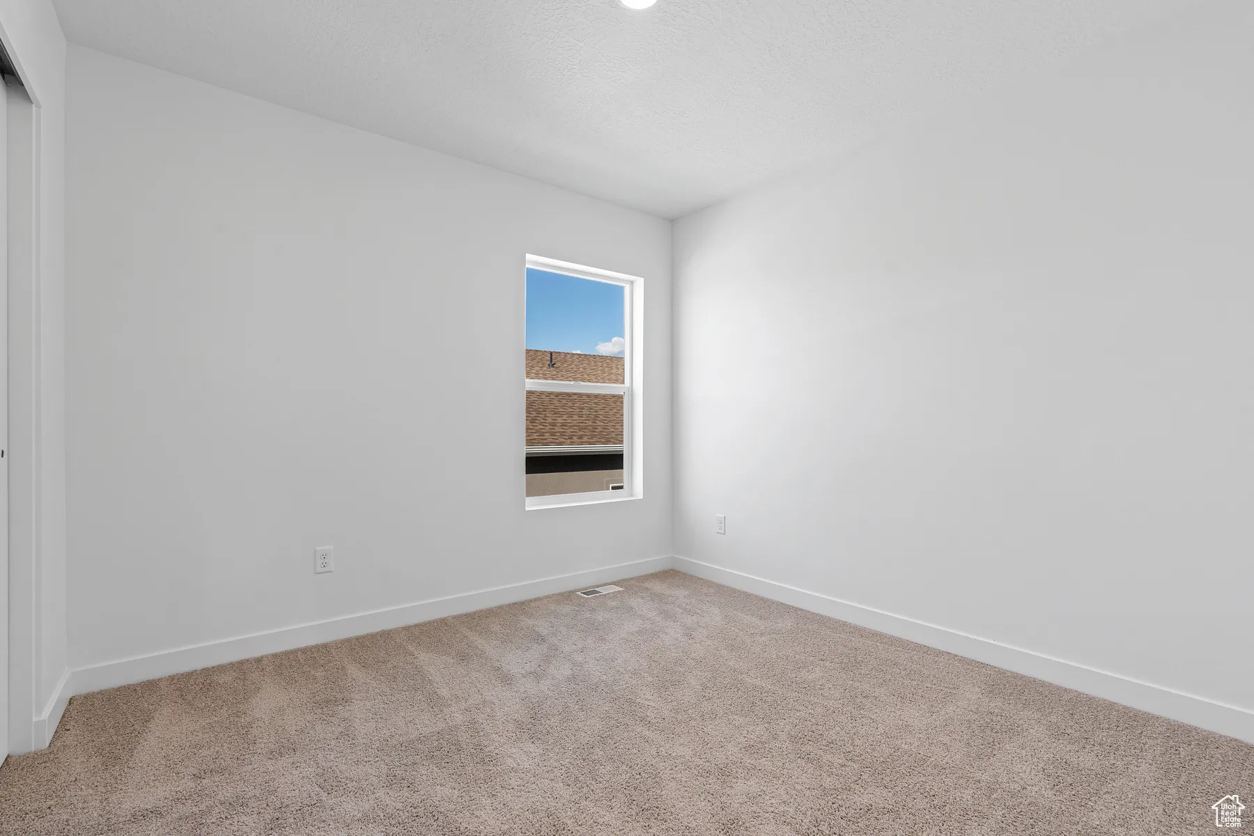 Spare room featuring baseboards, visible vents, and carpet floors