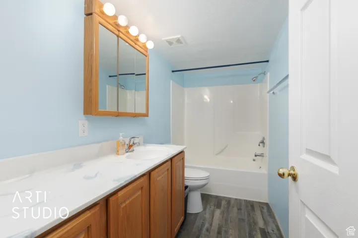 Full bathroom featuring shower / bathtub combination, vanity, and dark wood finished floors