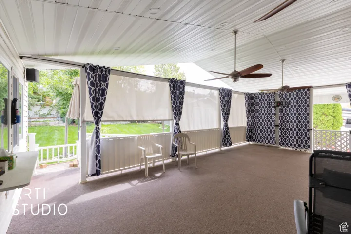 Unfurnished sunroom featuring lofted ceiling and a ceiling fan