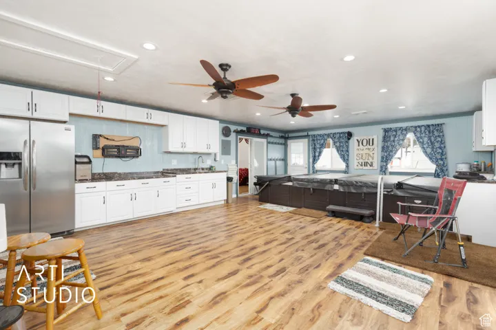 Living area with light wood-type flooring, attic access, ceiling fan, and recessed lighting