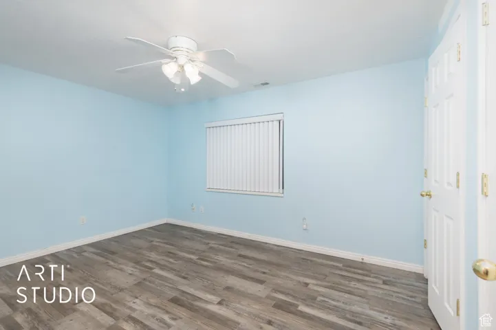 Spare room with dark wood finished floors and a ceiling fan