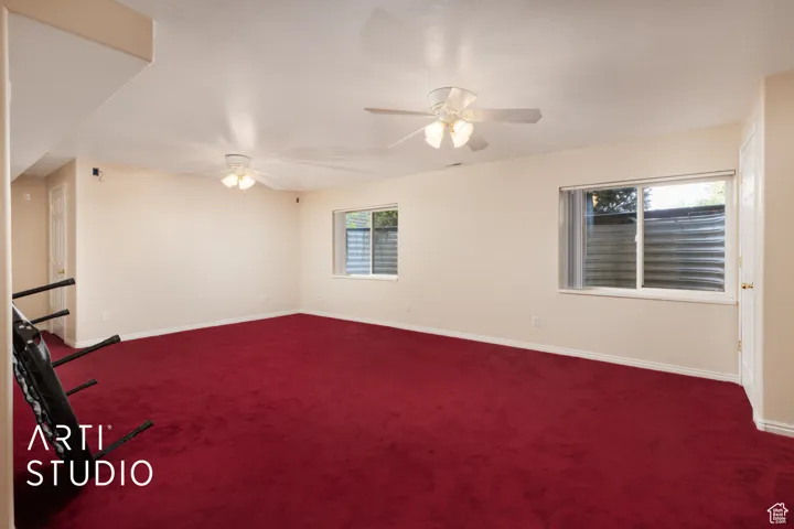 Spare room featuring carpet and ceiling fan