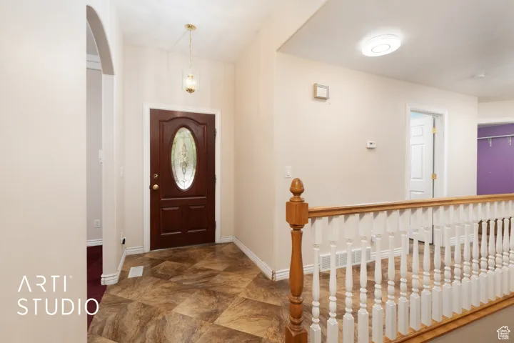 Foyer with baseboards and arched walkways
