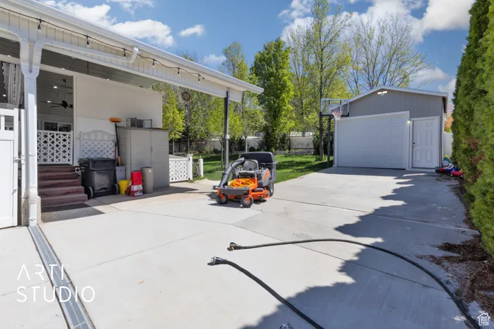 View of patio / terrace with an outdoor structure, a garage, and fence