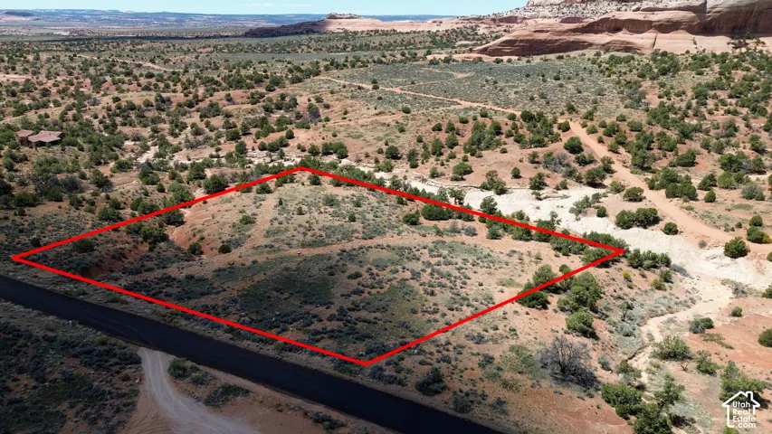 Aerial view of sparsely populated area with property parcel outlined and a desert landscape