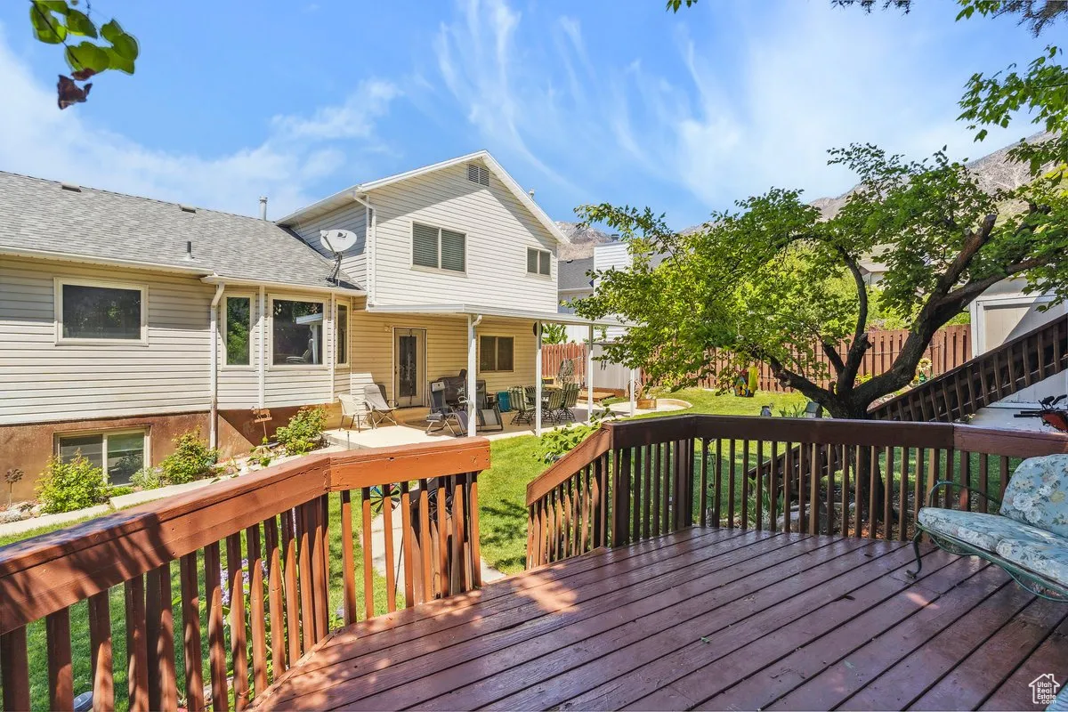 Wooden deck featuring a patio and a yard