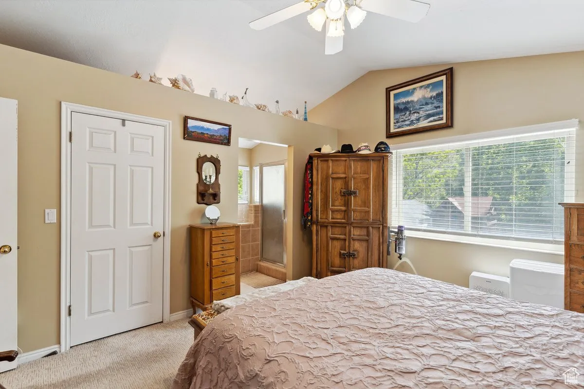 Bedroom with carpet, vaulted ceiling, and baseboards