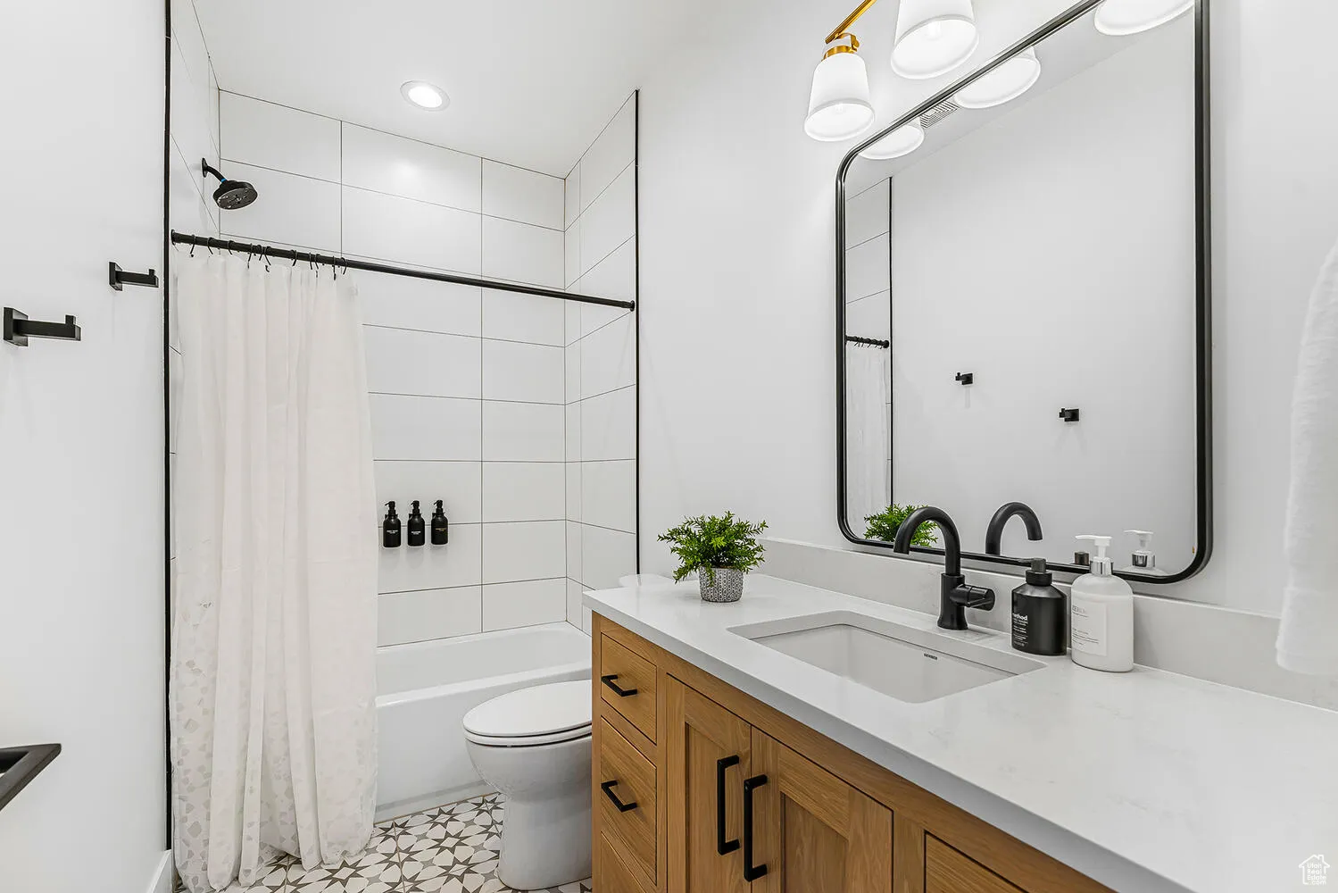 Full bathroom featuring toilet, vanity, and shower / bathtub combination with curtain