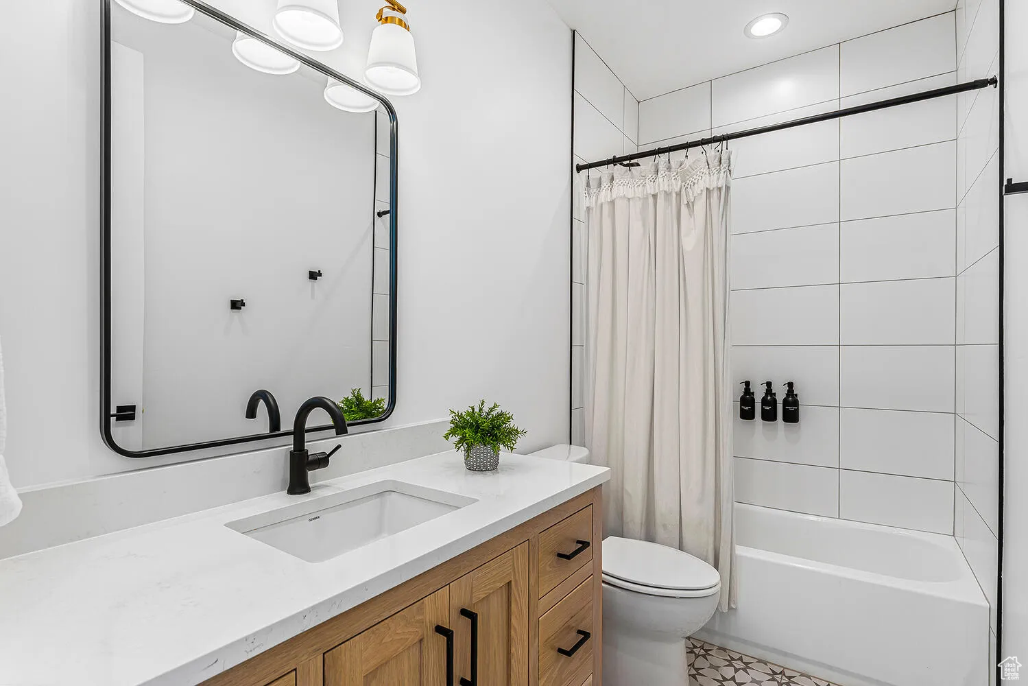 Bathroom with toilet, vanity, shower / tub combo with curtain, and recessed lighting