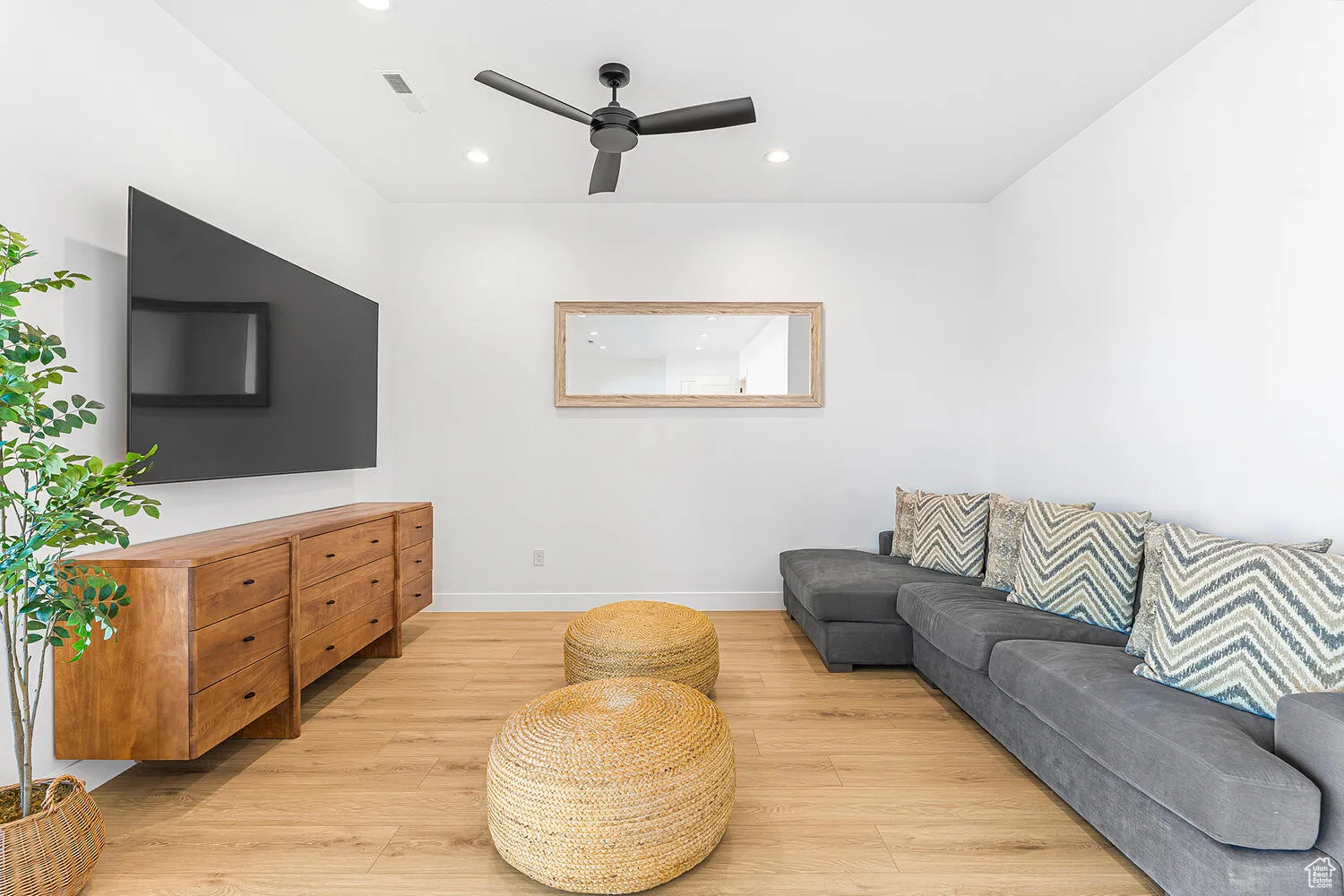 Living room with light wood-type flooring, a ceiling fan, recessed lighting, and baseboards