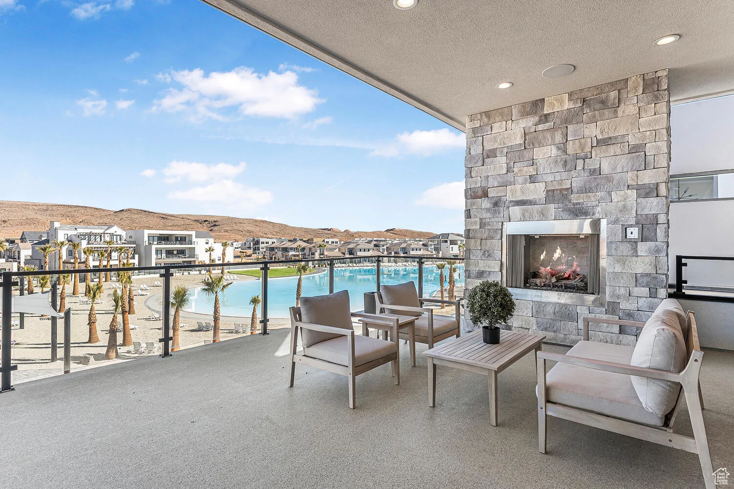 Balcony featuring an outdoor stone fireplace, a mountain view, and view of pool