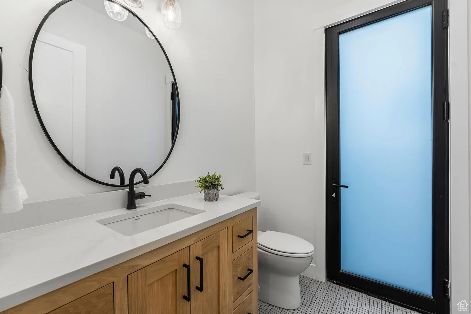 Half bathroom with vanity, toilet, and tile patterned floors