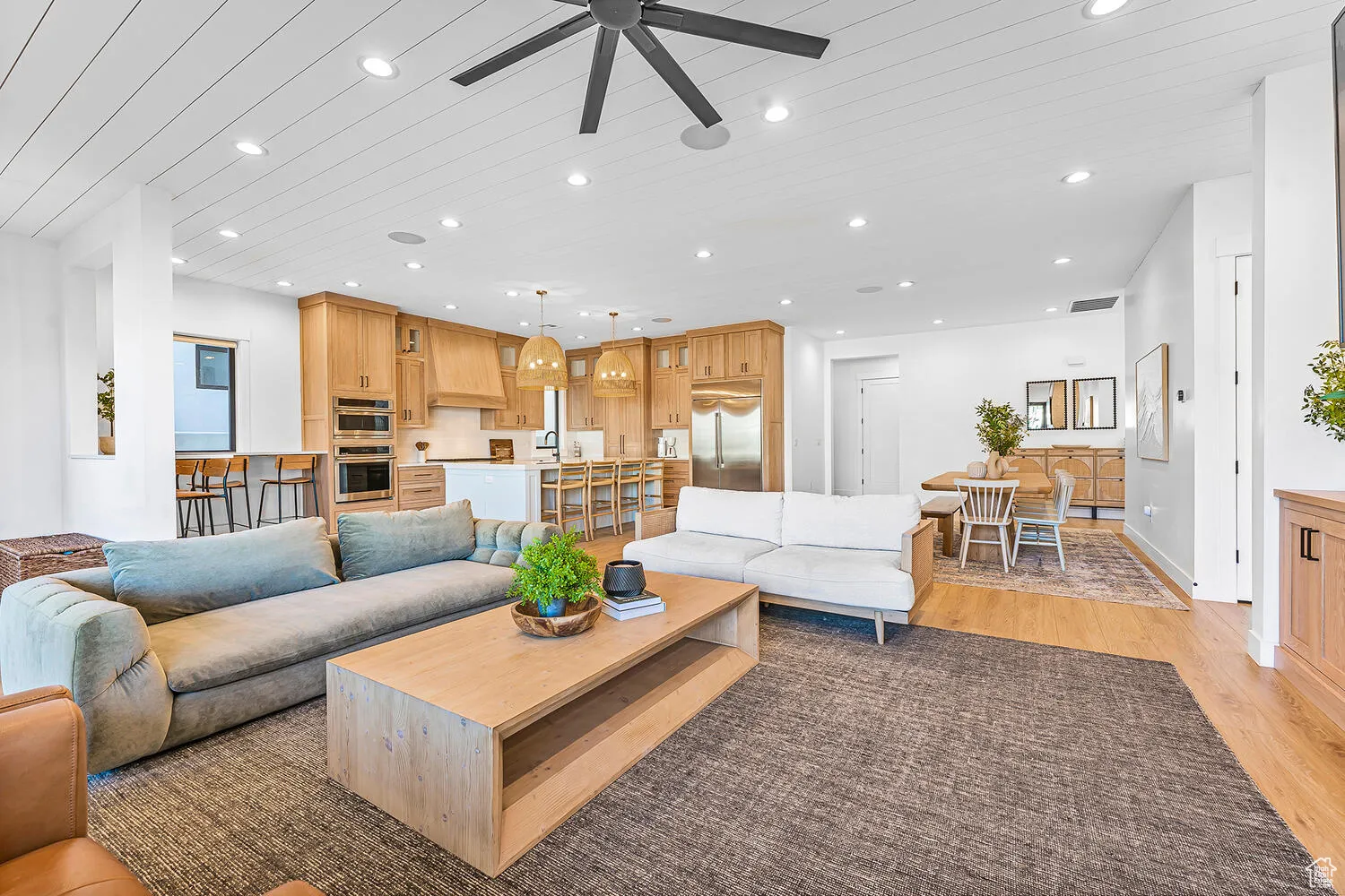 Living room featuring light wood finished floors, recessed lighting, ceiling fan, and wooden ceiling