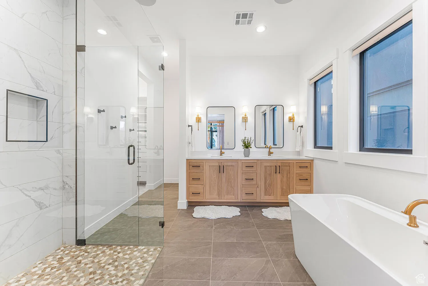 Full bathroom featuring a shower stall, double vanity, a freestanding tub, and recessed lighting