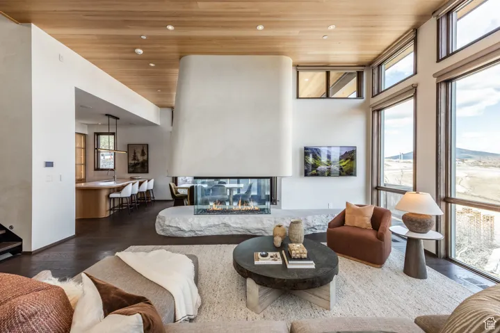 Living room featuring wooden ceiling, wood finished floors, recessed lighting, and a multi sided fireplace
