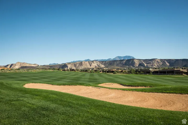 View of property's community featuring a mountain view, view of golf course, and a yard
