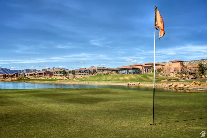 View of property's community featuring a water and mountain view and a lawn