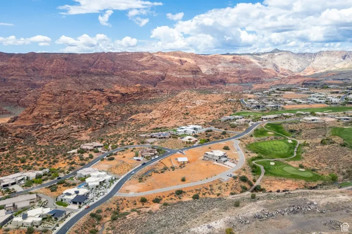 Aerial overview of property's location featuring a mountain backdrop and a golf club