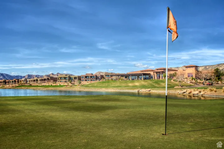 Surrounding community with a water and mountain view and a lawn