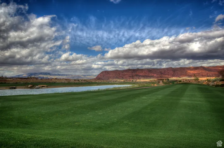 View of home's community with a water and mountain view and view of golf course