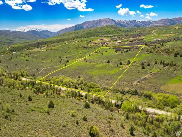 Aerial view of property with approximate property parcel outlined featuring a mountain backdrop