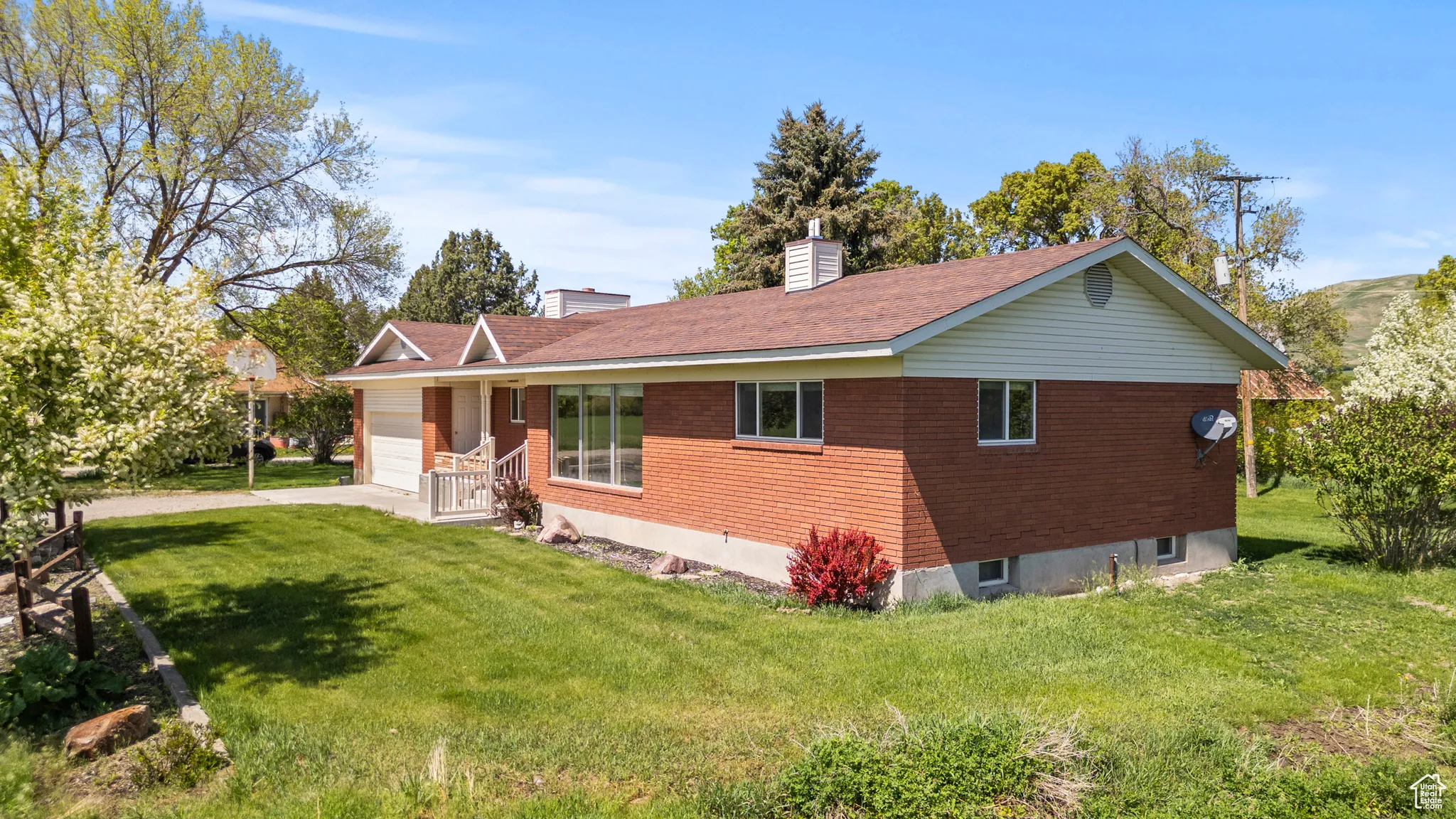 View of front facade with a garage, a front lawn, a chimney, and driveway