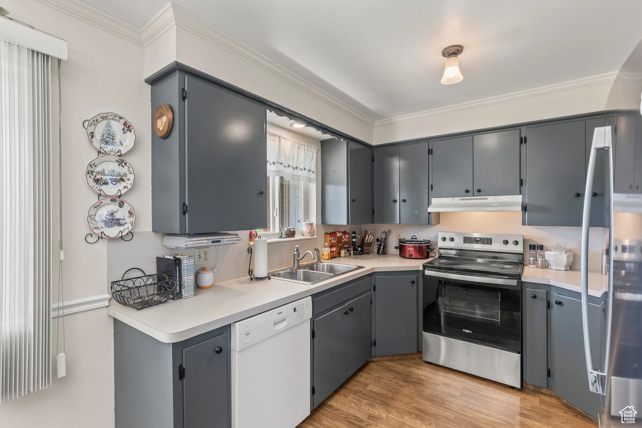Kitchen with electric range, a sink, dishwasher, ornamental molding, and gray cabinets