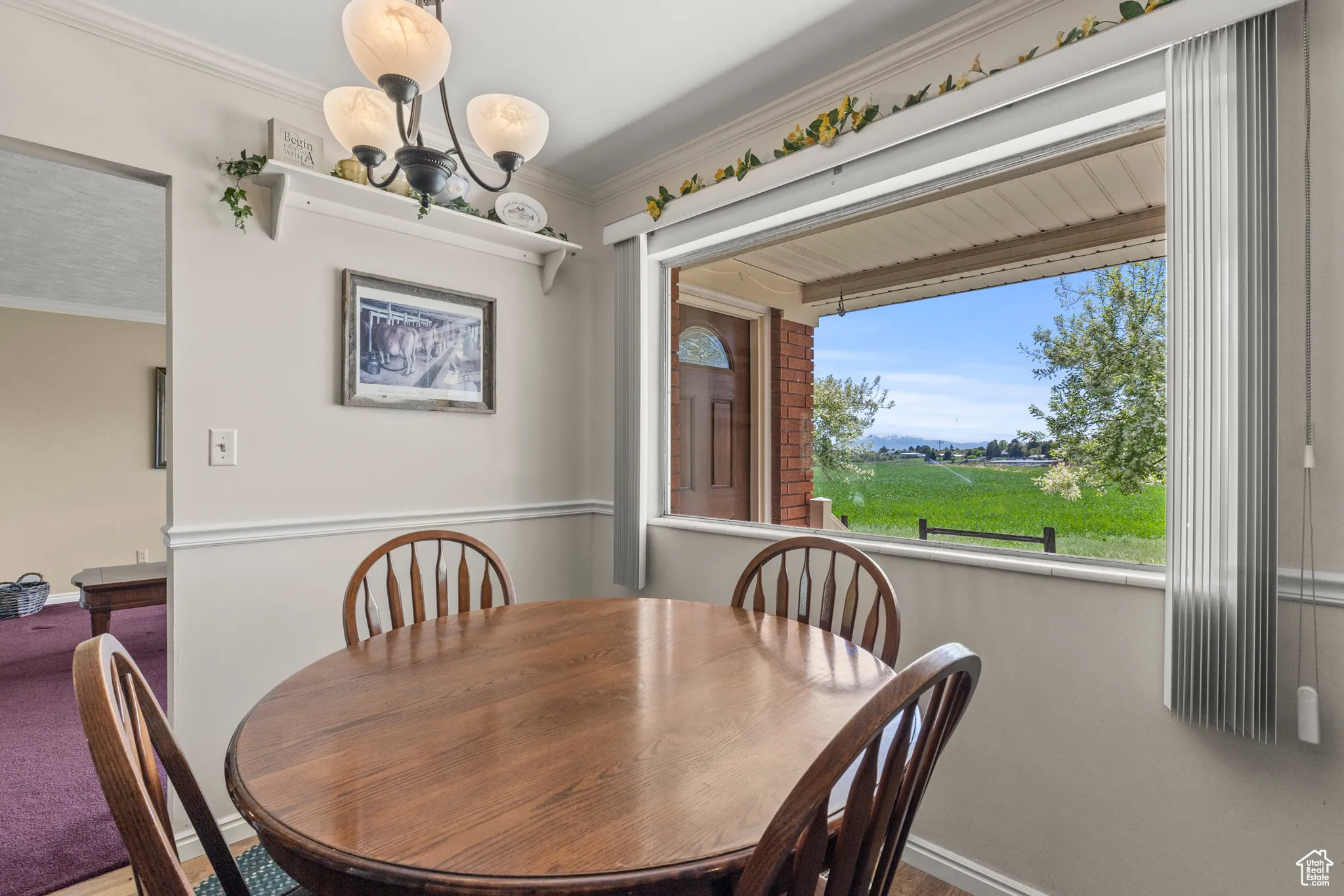Dining space featuring baseboards, a chandelier, and crown molding