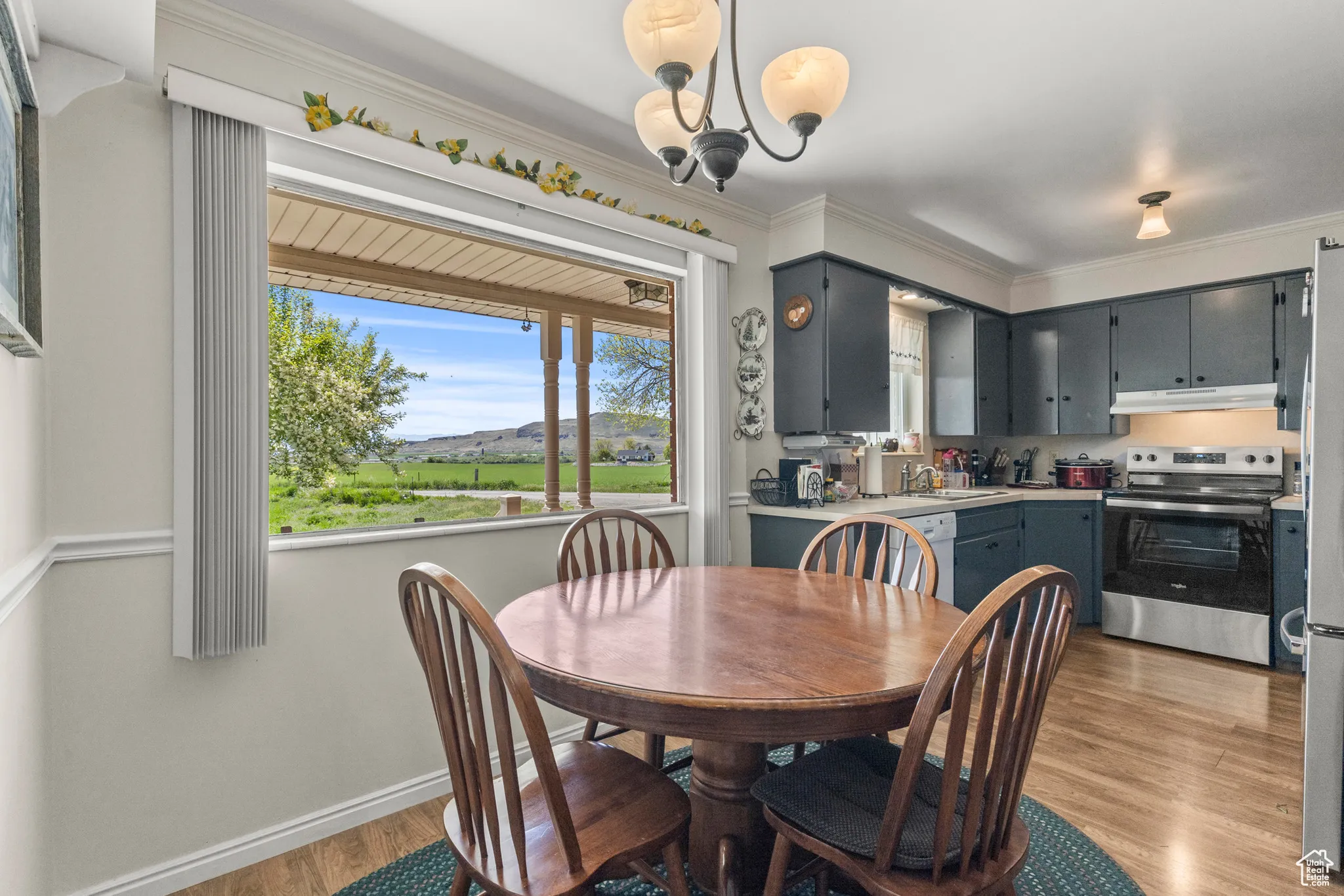 Dining room with light wood-style flooring, crown molding, a chandelier, and baseboards