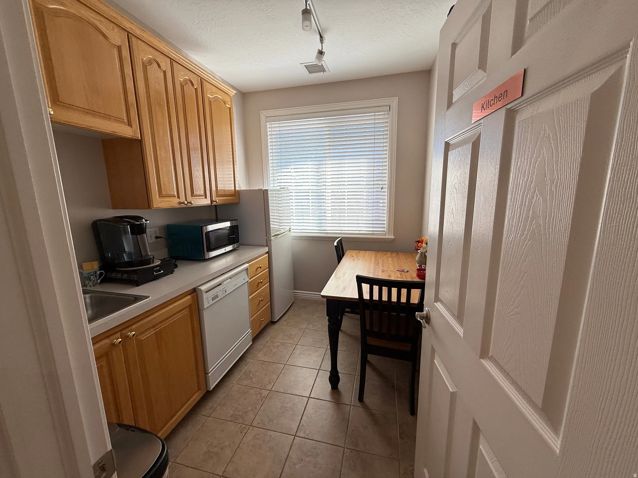 Community break room featuring refrigerator, table, microwave, dishwasher and coffee maker.