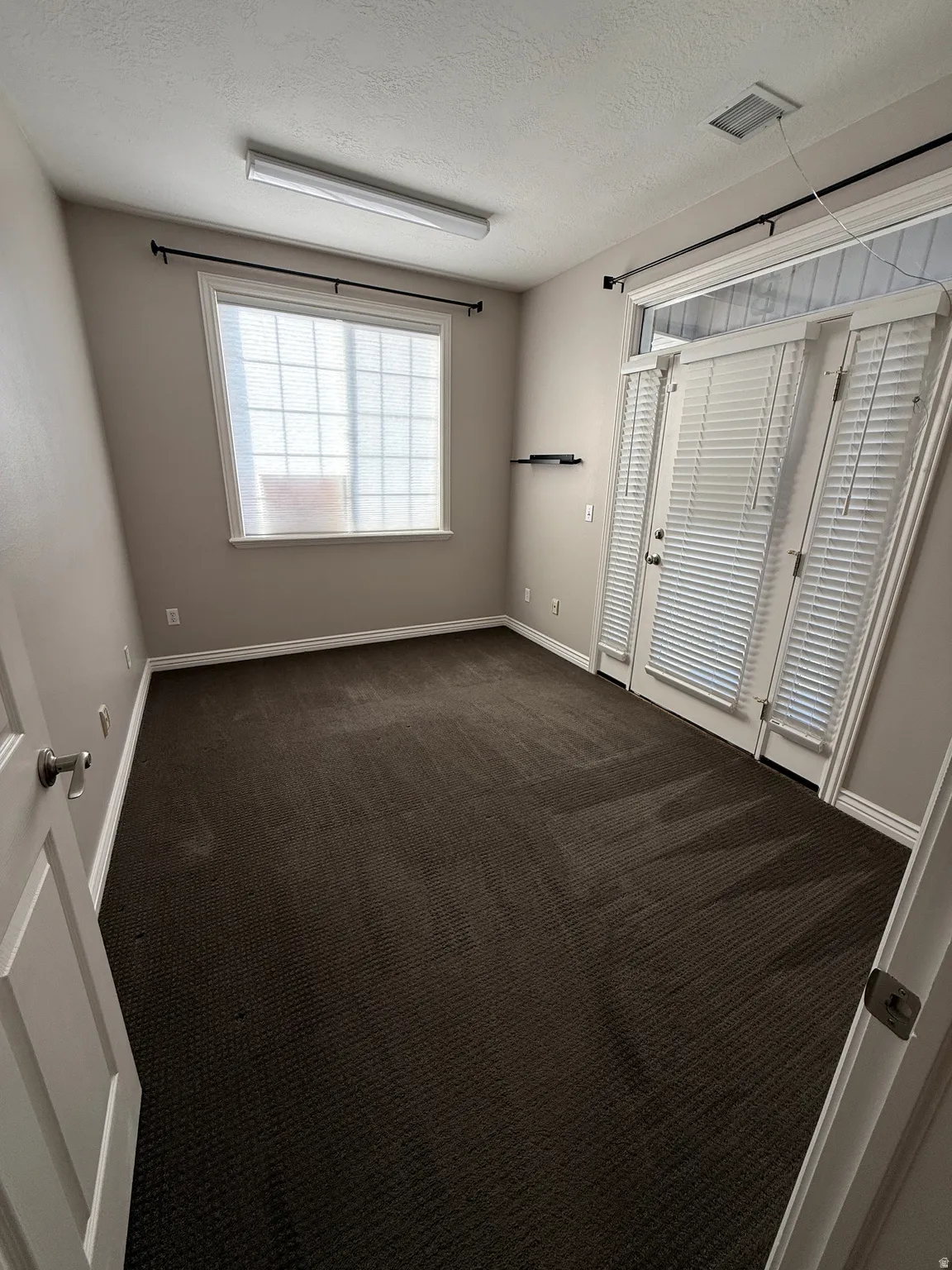 Suite 209 featuring a textured ceiling and dark colored carpet