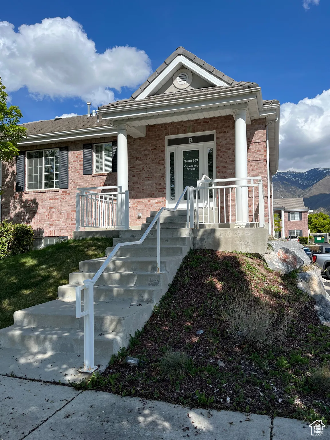 View of front of property with brick siding, a porch, and a mountain view
