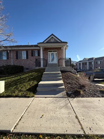 View of front of house featuring brick siding and covered porch