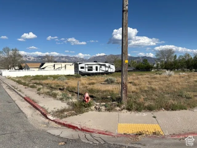 View of front facade featuring a mountain view and fence