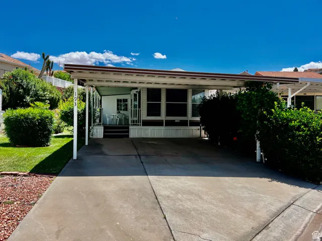 Manufactured / mobile home featuring an attached carport and concrete driveway