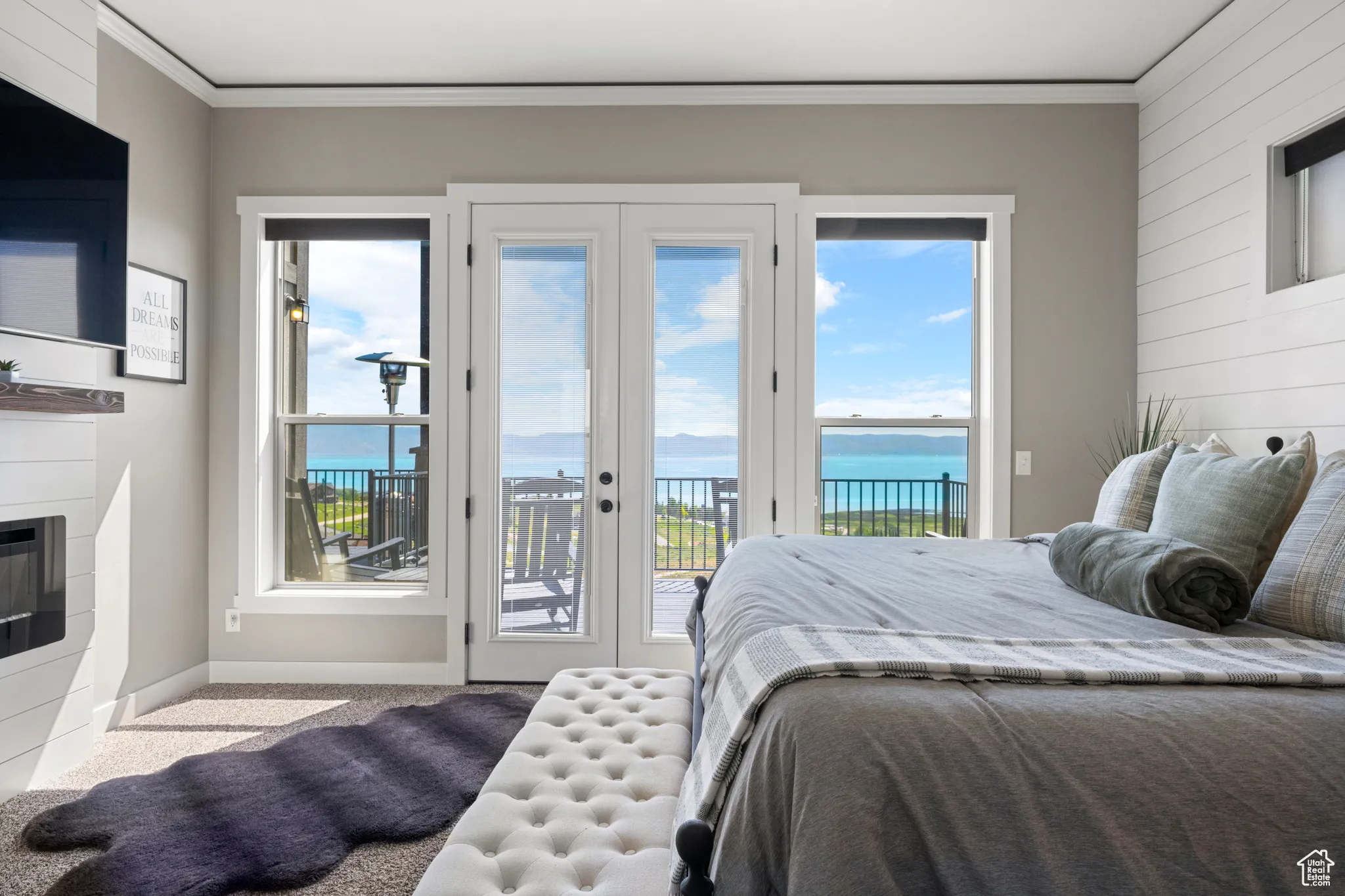 Bedroom featuring access to outside, carpet floors, crown molding, a glass covered fireplace, and wood walls