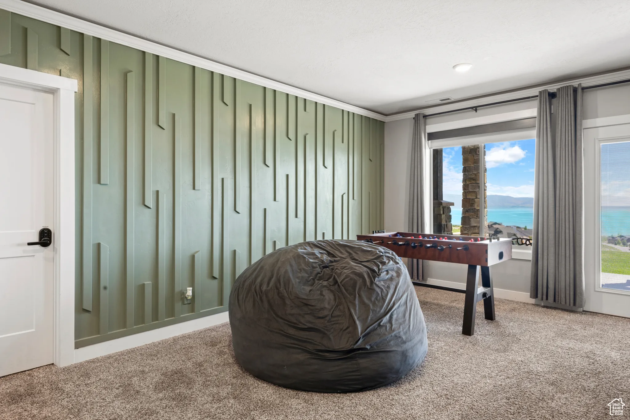 Living area with carpet flooring, a water view, and ornamental molding